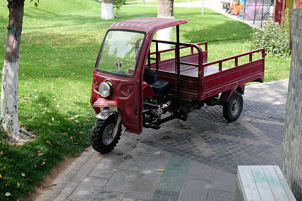 istock Red three-wheeled truck parked on a pathway in a green park during daylight hours 2205104570