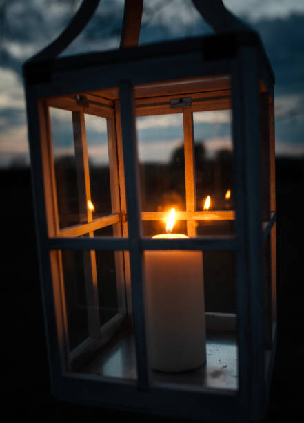 istock Close-up of a Burning Candle in a Rustic Lantern at Dusk 2205108913