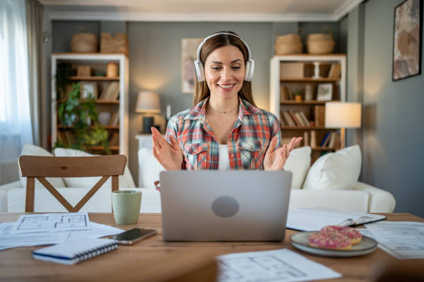 istock Architect wearing headphones making video call from home 2205111617