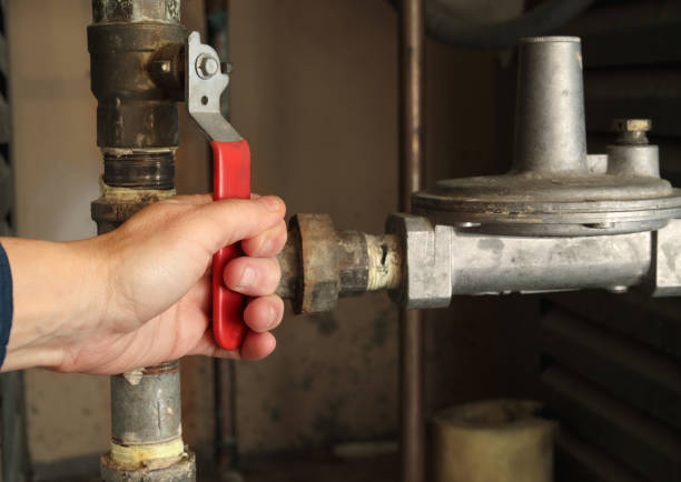 istock Technician using shut-off valve in front of gas pressure regulator. 2205112186