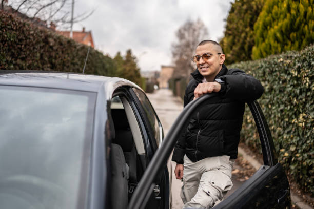 istock Man Standing Beside a Car on a Residential Street 2205113101