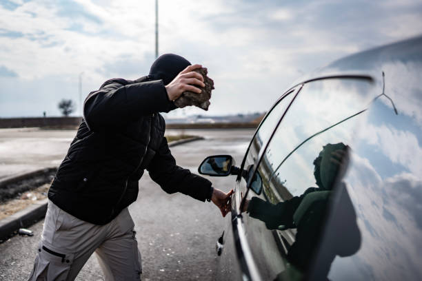 istock Individual Attempting a Break-In on a Car in Broad Daylight 2205113182