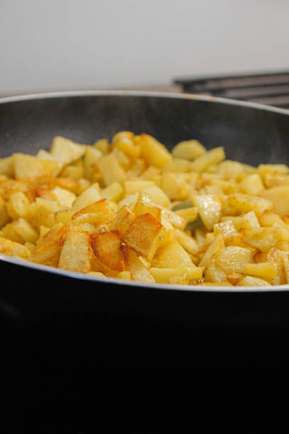 istock fried potatoes cut into pieces in a black frying pan with dill close-up 2205113211