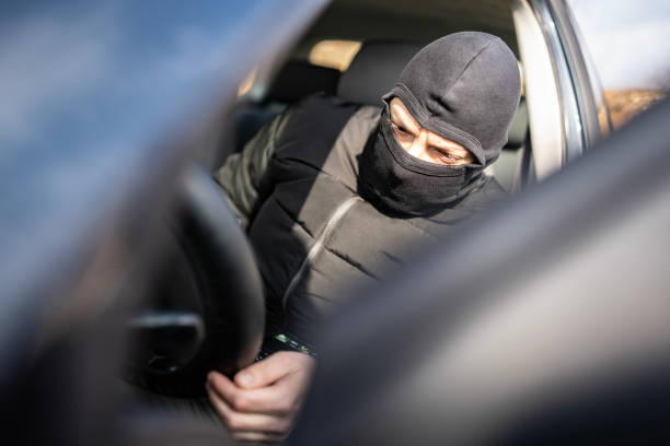 istock Masked Individual Sitting in a Car with a Suspicious Expression 2205113743