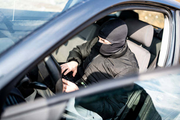 istock Masked Individual Using a Laptop Inside a Parked Vehicle Outdoors 2205113763
