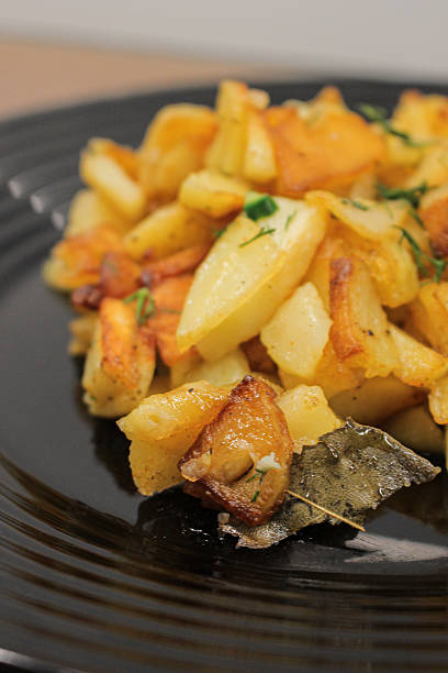 istock fried potatoes cut into pieces in a black plate with dill close-up 2205113799