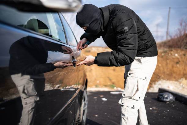 istock Masked Individual Attempting Unauthorized Entry Into a Parked Vehicle in Daylight 2205113848