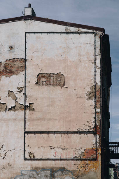 istock Facade of old and damaged building with falling off plaster 2205114706