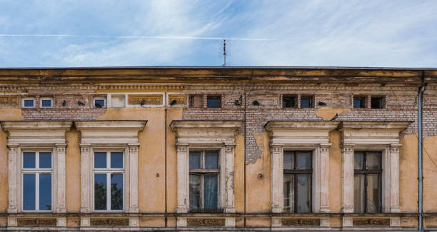 istock Facade of old and damaged building with falling off plaster 2205114708