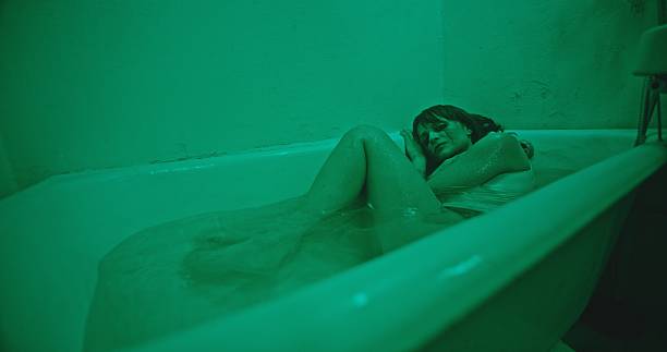 istock A Serene and Thoughtful Reflection in a Luxurious Bathtub with Stunning Atmospheric Green Lighting 2205115181