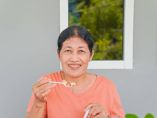 istock senior woman  eating salad 2205118537