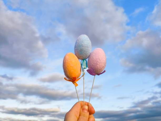 Easter eggs. Easter eggs in hand in the meadow against the background of a bright sky