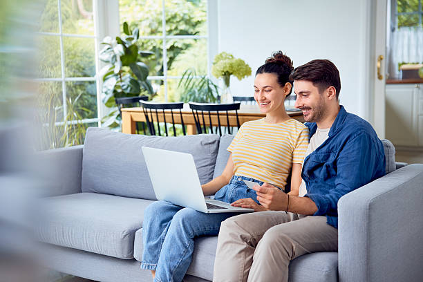 istock Young couple on sofa paying for online shopping 2205123219