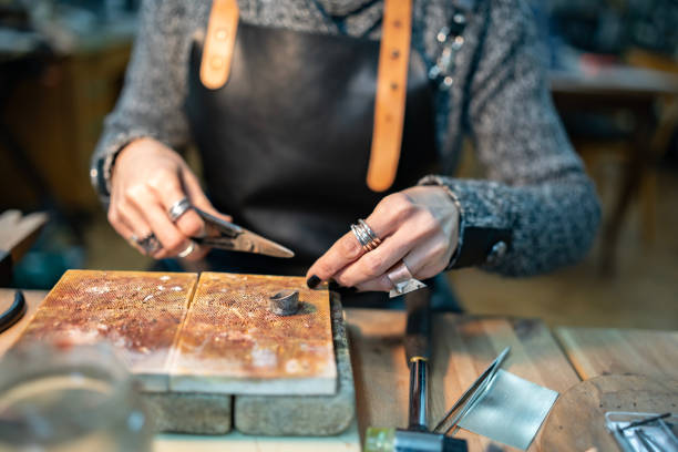 istock Craftsman Working on Metal Jewelry with Tools in a Workshop Setting 2205123529