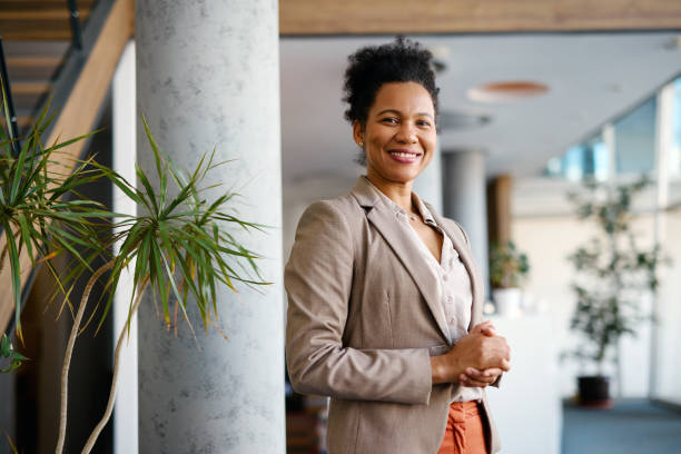 istock Confident businesswoman smiling in modern office lobby 2205123625
