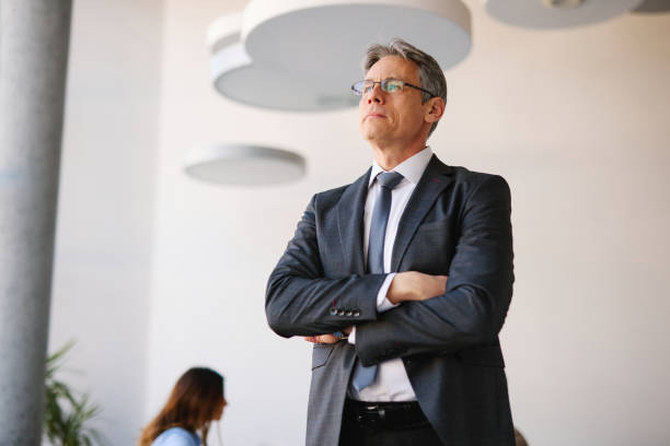 istock Confident businessman standing with arms crossed in modern office 2205123690