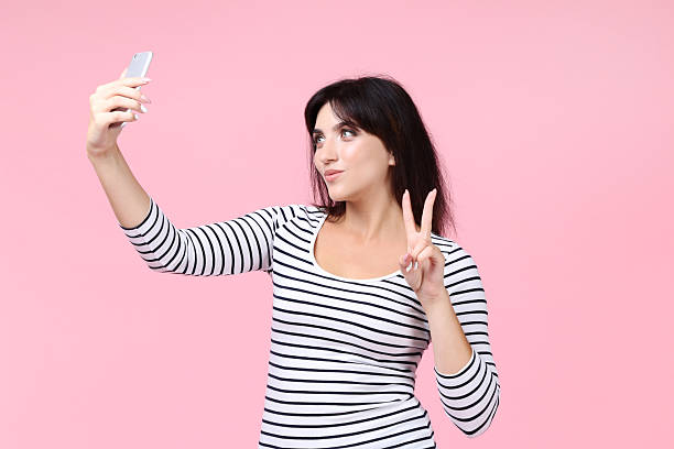 istock Young woman making selfie on pink background 2205123692