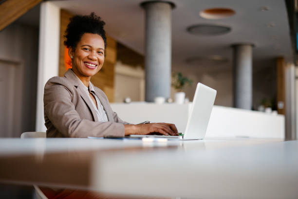 istock Smiling businesswoman working on laptop in modern office 2205123779