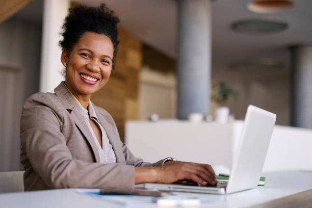 istock Smiling businesswoman working on laptop in modern office 2205123794