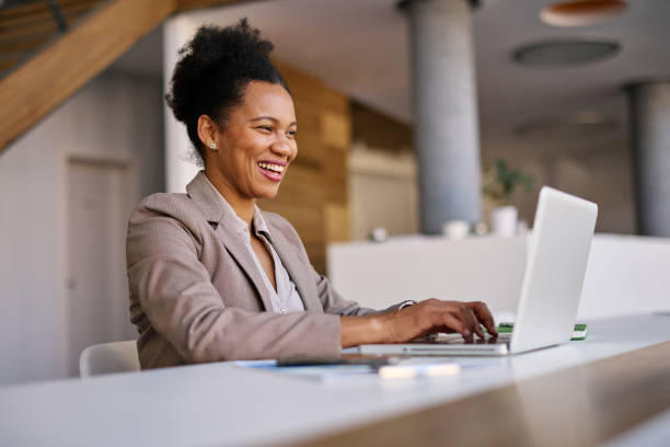 istock Smiling businesswoman working on laptop in modern office 2205123795