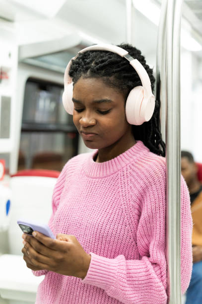 istock Student listening to music on public transport 2205124345