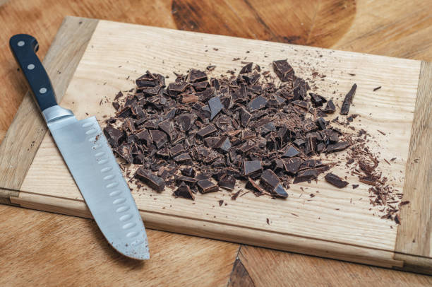 istock Knife with chopped dark chocolate on wooden board 2205125626