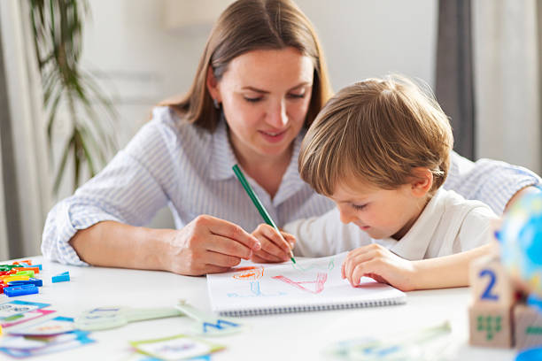 istock Mother teaching child to draw in homeschool setting 2205125942