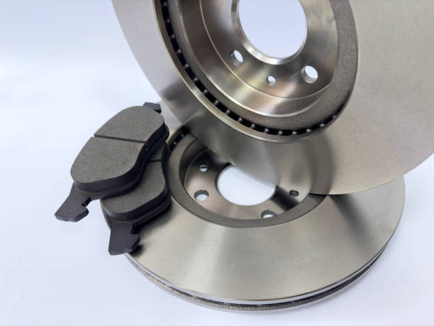Closeup photo of a brake disc and pads on a white surface