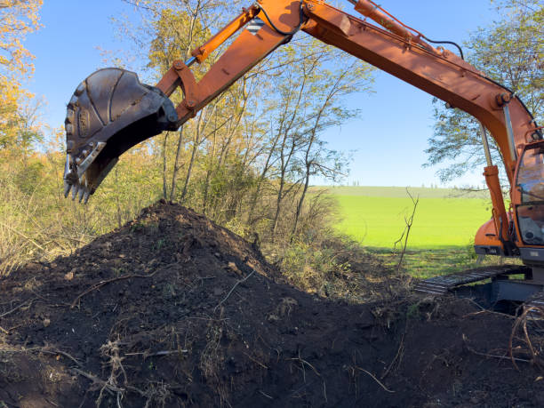 istock A large orange excavator is actively digging a sizeable hole in a field 2205126976