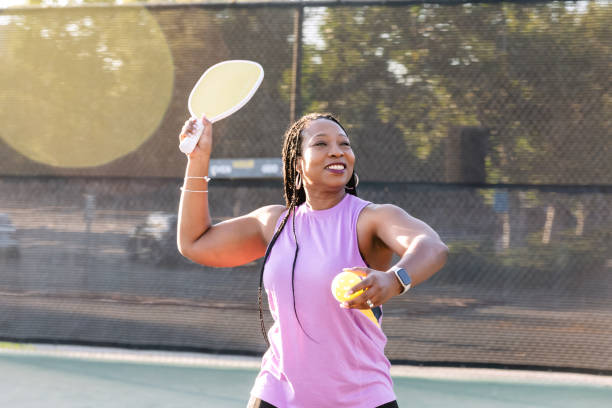 istock Woman playing pickle ball during golden hour 2205128755