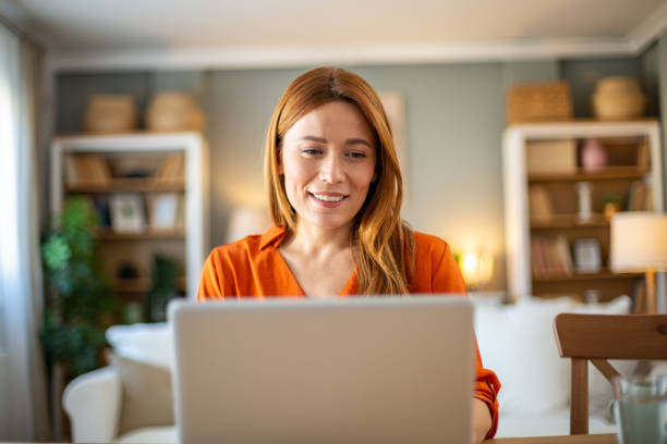 istock Front view of smiling woman working on laptop 2205129601