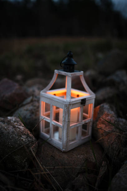istock Rustic Lantern with a Flickering Candle on Rocks at Night 2205130248