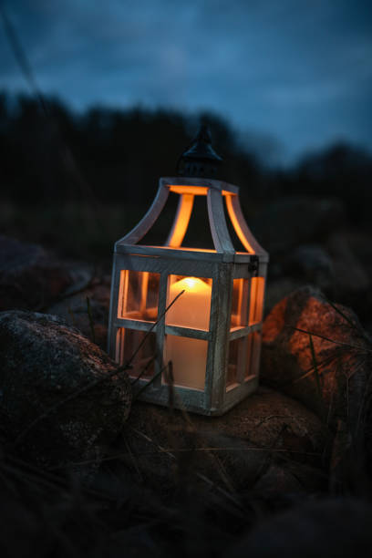 istock Rustic Lantern with a Flickering Candle on Rocks at Night 2205130267