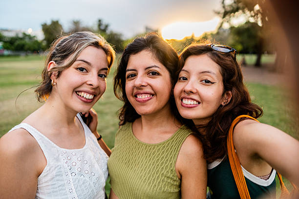 Sisters taking selfie in a public park - camera point of view
