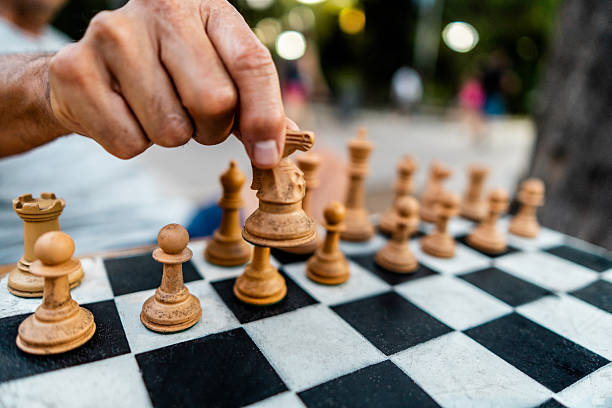 Close-up of a man playing chess board in the square