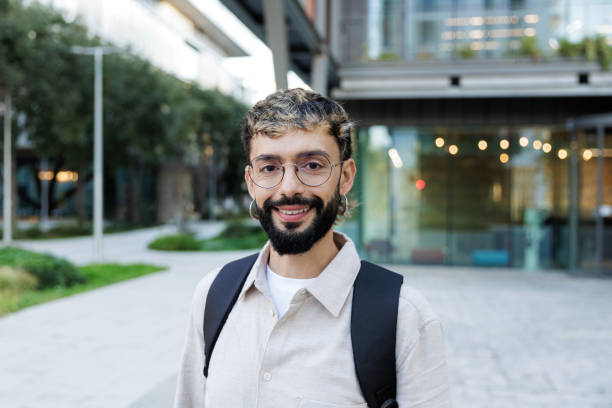 istock Young businessman smiling outside modern office building 2205134406