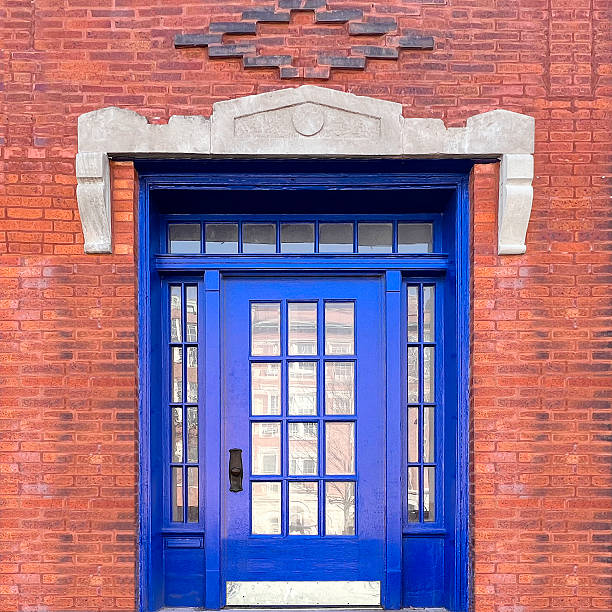 Cobalt blue door with glass panes highlighted by a diamond-shaped brick pattern and geometric stone framing.