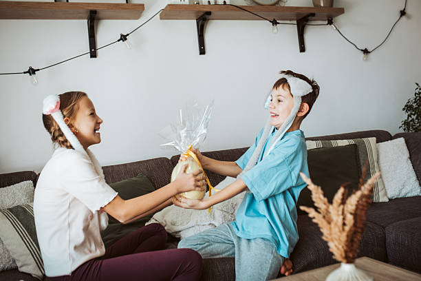 istock Little girl gifting large Easter egg to young boy. 2205136366