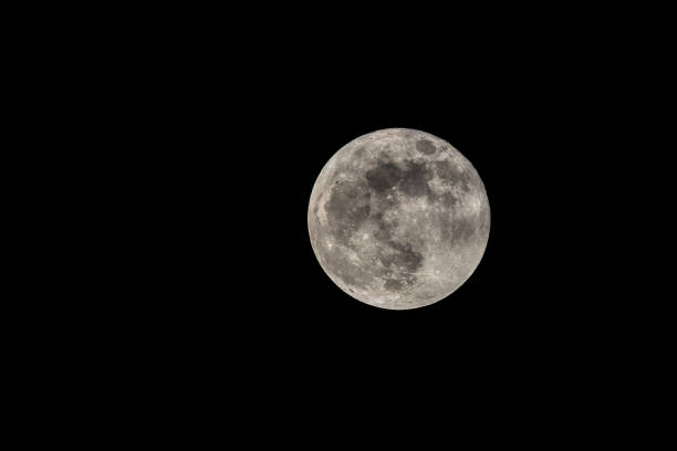 A large, bright full moon is shining in the night sky. The moon is surrounded by a dark background, which emphasizes its size and brightness. Concept of wonder and awe at the beauty of the moon