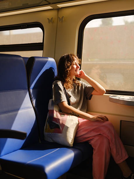 istock Woman looking through window traveling by train in summer 2205139759