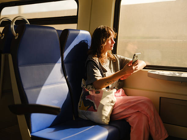 istock Woman looking through window traveling by train in summer 2205139761