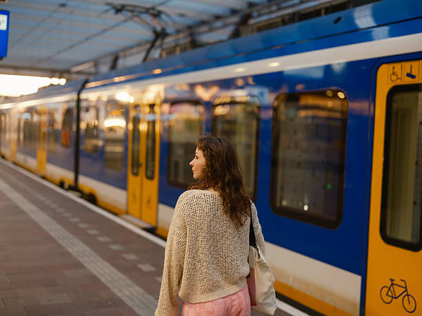istock Woman boarding  the train on railway station  platform 2205139767