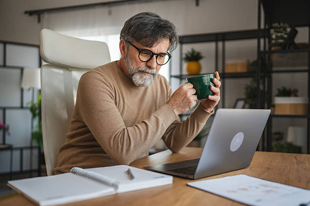 istock mature senior man relax from work and drink coffee at home office 2205142504