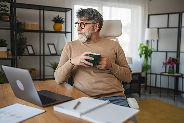 istock mature senior man relax from work and drink coffee at home office 2205142894