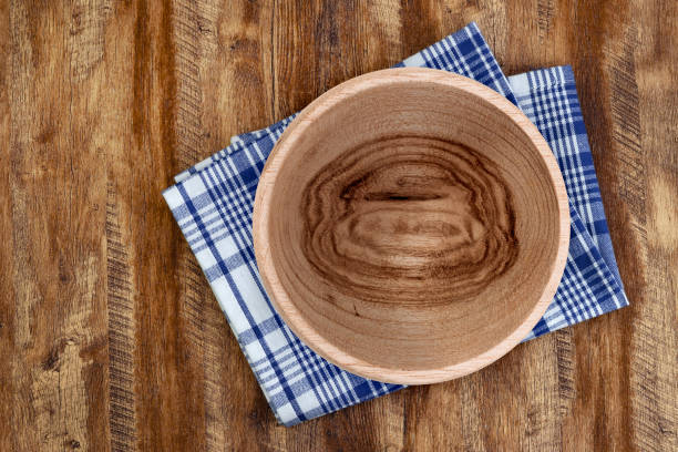 istock Rustic wooden bowl on checkered napkin over a textured wooden table. 2205143377