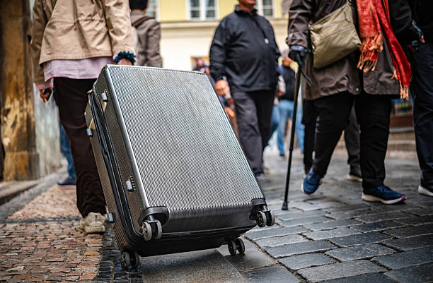 Tourist With A Big Suitcase On a Cobblestone Street Amidst A Crowd