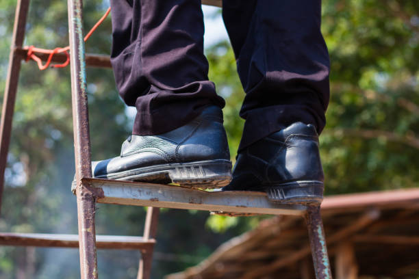 Construction worker wearing safety shoes in work area, work safety concept