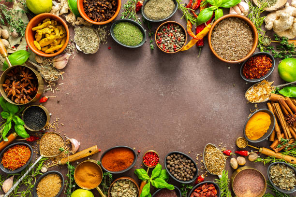 istock A diverse collection of vibrant spices and herbs, elegantly positioned on a brown backdrop, exuding natural beauty and a burst of fragrances, spice frame 2205155825