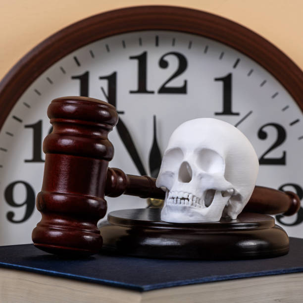 Judge's gavel and human skull against clock background