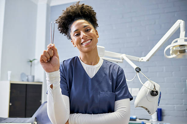 istock Smiling Dental Professional Holding Dental Tool in Modern Clinic Setting 2205186988